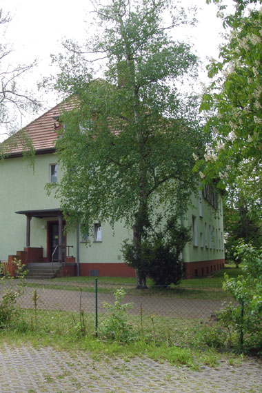 kleines Bild - Vorgarten Ignatz-Stroof-Straße 16-17 in Bitterfeld hat 18 Wohnungen, 1 RWE, Fernwärme, betreutes Wohnen mit viel Grünfläche. Viel Grün und Gartennutzung möglich. Mehrere Garagenkomplexe im Wohngebiet vorhanden. 